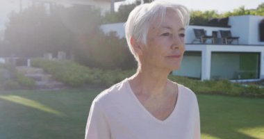 Huzurevinde güneşli bir günde bahçedeki mutlu beyaz kadın portresi. sağlıklı, aktif emeklilik ve bedensel bütünlük.