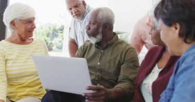 Huzurevinde konuşan ve dizüstü bilgisayar kullanan mutlu yaşlılar. sağlıklı, aktif emeklilik ve bedensel bütünlük.