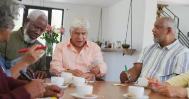 Huzurevinde çay içip tombala oynayan kıdemli insanlar. sağlıklı, aktif emeklilik ve bedensel bütünlük.