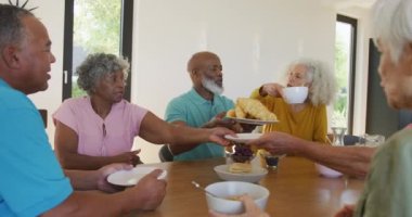 Happy senior diverse people having breakfast at retirement home. healthy, active retirement and body inclusivity.