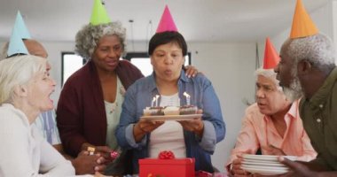 Doğum günü partisinde pasta ve huzurevinde hediyelerle mutlu kıdemli insanlar. sağlıklı, aktif emeklilik ve bedensel bütünlük.