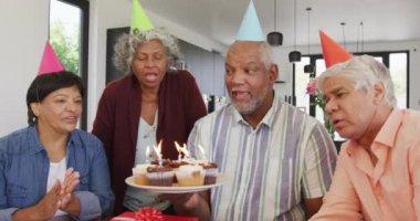 Doğum günü partisinde pasta ve huzurevinde hediyelerle mutlu kıdemli insanlar. sağlıklı, aktif emeklilik ve bedensel bütünlük.