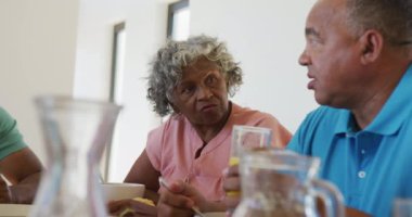 Happy senior diverse people having breakfast at retirement home. healthy, active retirement and body inclusivity.