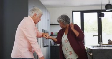 Huzurevinde mutfakta dans eden mutlu kıdemli çift. sağlıklı, aktif emeklilik ve bedensel bütünlük.