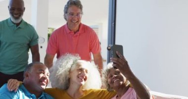 Happy senior diverse people taking selfie at retirement home. healthy, active retirement and body inclusivity.