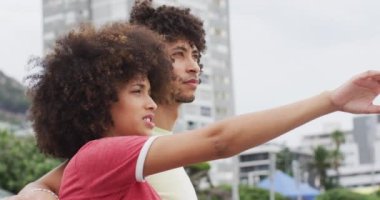 Afrika kökenli Amerikalı bir çift sahildeki gezinti güvertesine bakıyor. Aşk ve ilişki kavramı