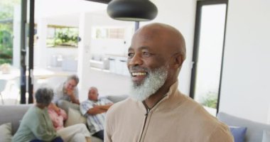 Portrait of happy senior african american man with other seniors at retirement home. healthy, active retirement and body inclusivity.