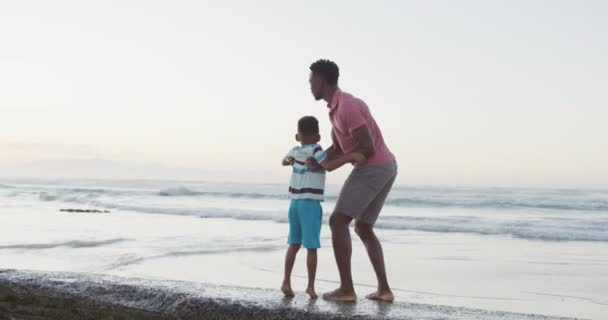 Afrykański Amerykański Ojciec Niosący Syna Słonecznej Plaży Zdrowe Aktywne Wakacje — Wideo stockowe