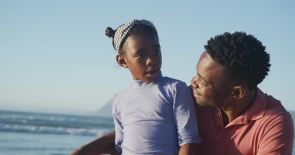 快乐的非洲裔美国父亲在阳光灿烂的海滩上与女儿交谈 健康而活跃的海滨假期 — 图库视频影像