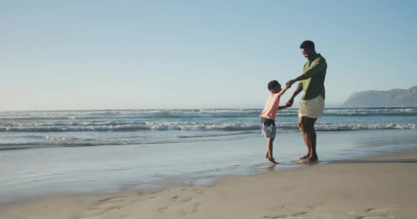 Szczęśliwego Afrykańskiego Ojca Tańczącego Synem Słonecznej Plaży Zdrowe Aktywne Wakacje — Wideo stockowe