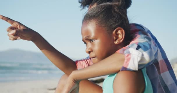 Felice Madre Afroamericana Seduta Con Figlia Sulla Spiaggia Soleggiata Tempo — Video Stock