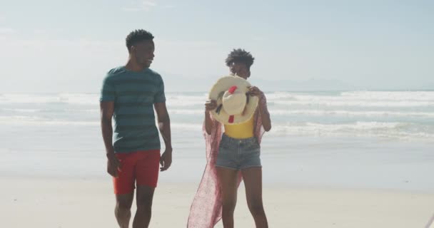 Heureux Couple Afro Américain Marchant Avec Chapeau Sur Une Plage — Video