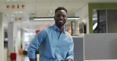 Ofisteki kameraya bakan mutlu Afro-Amerikan iş adamının videosu. İş adamları ve ofis kavramında çalışmak.