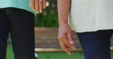 Bahçede el ele tutuşan yaşlı çiftlerin orta bölümünün videosu. aktif emeklilik yaşam tarzı, kıdemli ilişki ve birlikte zaman geçirme kavramı.