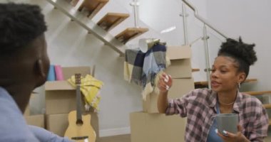 Yeni eve taşındıktan sonra kahve içen mutlu Afro-Amerikan çiftin videosu. Aşk, ilişki ve birlikte yeni bir hayata başlamak..