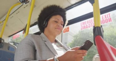 Otobüste akıllı telefon kullanan mutlu ve melez bir kadın. dijital göçebe hareket halinde, beden içeriği.