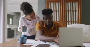 Ciddi bir Afrikalı Amerikalı çiftin dizüstü bilgisayar kullanıp faturalarını ödediği bir video. ilişki, finans, para ve sorumluluk kavramı.