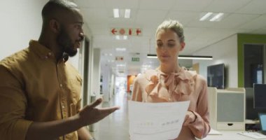 Mutlu erkek ve kadın iş arkadaşları konuşuyor ve ofiste yürüyor. Modern bir ofiste çalışmak..