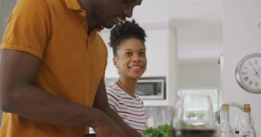 Mutfakta birlikte yemek yapan mutlu Afro-Amerikan çiftin videosu. Aşk, ilişki, birliktelik ve evde kaliteli zaman geçirme.