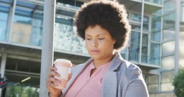 Artı, şehirde yürüyen ve kahve içen melez bir kadın. dijital göçebe hareket halinde, beden içeriği.