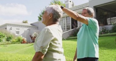 Bahçede el ele tutuşup dans eden mutlu son sınıf çifti videosu. aktif emeklilik yaşam tarzı, kıdemli ilişki ve birlikte zaman geçirme kavramı.