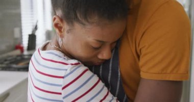 Mutfakta kucaklaşan mutlu Afro-Amerikan çiftin videosu. Aşk, ilişki, birliktelik ve evde kaliteli zaman geçirme.