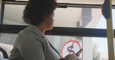 Otobüste akıllı telefon kullanan mutlu ve melez bir kadın. dijital göçebe hareket halinde, beden içeriği.