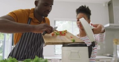 Mutfakta birlikte yemek yapan mutlu Afro-Amerikan çiftin videosu. Aşk, ilişki, birliktelik ve evde kaliteli zaman geçirme.