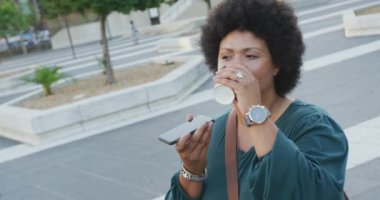 Şehirde akıllı telefondan konuşan mutlu ve melez bir kadın. dijital göçebe hareket halinde, beden içeriği.