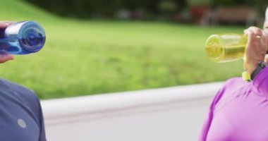 Tenis antrenmanından sonra su içen yaşlı çiftlerin yorgun videosu. aktif emeklilik yaşam tarzı, kıdemli ilişki ve tenis eğitim konsepti.