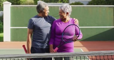 Tenis kortunda raket tutan mutlu son sınıf çifti videosu. aktif emeklilik yaşam tarzı, kıdemli ilişki ve tenis eğitim konsepti.