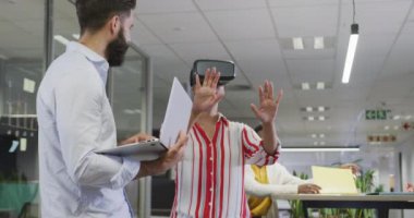 Ofiste VR kulaklığı kullanan mutlu erkek ve kadın iş arkadaşları. Modern bir ofiste çalışmak..