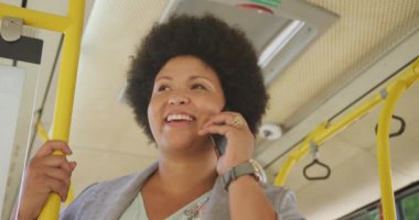 Otobüste akıllı telefondan konuşan mutlu, melez bir kadın. dijital göçebe hareket halinde, beden içeriği.