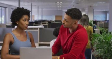 Çeşitli erkek ve kadın iş arkadaşları ofiste dizüstü bilgisayarla konuşuyor ve kullanıyor. Modern bir ofiste çalışmak..