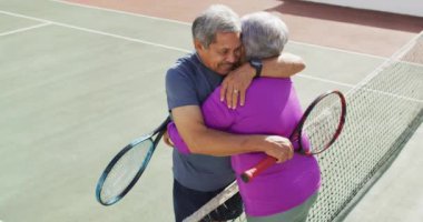 Tenis kortunda kucaklaşan mutlu son sınıf çifti videosu. aktif emeklilik yaşam tarzı, kıdemli ilişki ve tenis eğitim konsepti.