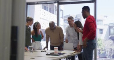 Çeşitli erkek ve kadın iş arkadaşları toplantıda konuşuyor. Modern bir ofiste çalışmak..