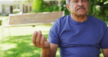 Bahçede yoga yapan rahat, çift ırklı son sınıf öğrencisinin videosu. aktif emeklilik yaşam tarzı ve egzersiz konsepti.