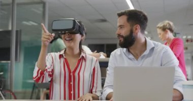 Ofiste VR kulaklığı kullanan mutlu erkek ve kadın iş arkadaşları. Modern bir ofiste çalışmak..