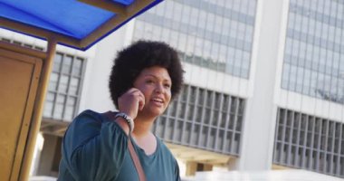 Artı, şehirde akıllı telefondan konuşan ve taksi çağıran melez bir kadın. dijital göçebe hareket halinde, beden içeriği.