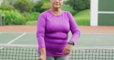 Tenis kortunda raket tutan mutlu son sınıf kadınının videosu. aktif emeklilik yaşam tarzı, hobi ve tenis eğitim konsepti.