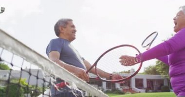 Tenis kortunda kucaklaşan mutlu son sınıf çifti videosu. aktif emeklilik yaşam tarzı, kıdemli ilişki ve tenis eğitim konsepti.