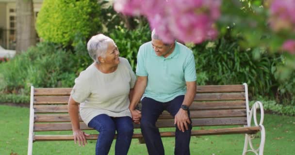 Video Feliz Pareja Ancianos Birraciales Abrazando Sentado Banco Jardín Estilo — Vídeos de Stock