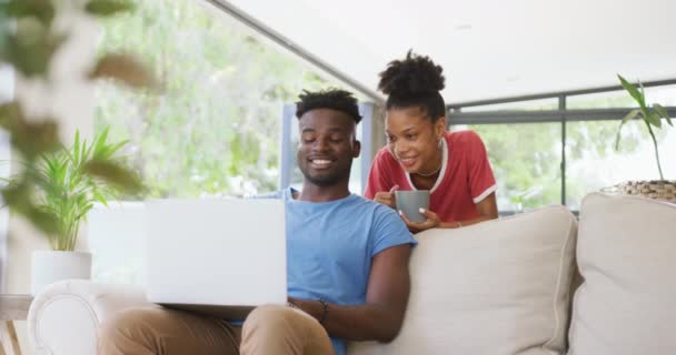 소파에 커피와 노트북을 아프리카 미국인 커플의 비디오 그리고 집에서 시간을 — 비디오
