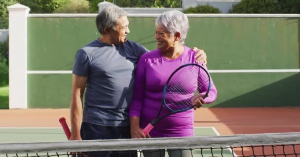 Video Una Feliz Pareja Ancianos Birraciales Con Raquetas Cancha Tenis — Vídeo de stock