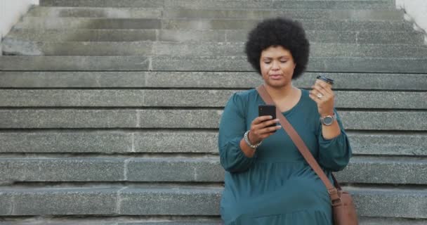 Happy Size Biracial Vrouw Met Behulp Van Smartphone Het Drinken — Stockvideo