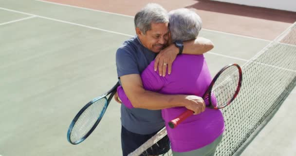 Video Van Gelukkig Biracial Senior Koppel Omarmen Tennisbaan Actief Pensioen — Stockvideo