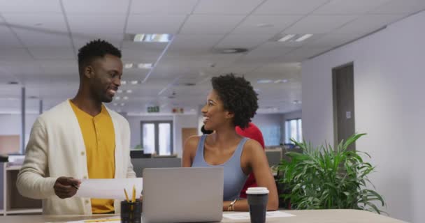 幸せなアフリカ系アメリカ人の男性と女性のビジネス同僚がノートパソコンを話し 使用しています 現代のオフィスで仕事をしています — ストック動画