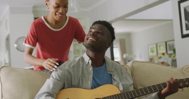 Vídeo Feliz Casal Afro Americano Sentado Sofá Cantando Tocando Guitarra — Vídeo de Stock