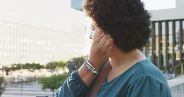 Szczęśliwy Rozmiar Biracial Kobieta Pomocą Smartfona Noszenia Słuchawek Mieście Cyfrowy — Wideo stockowe