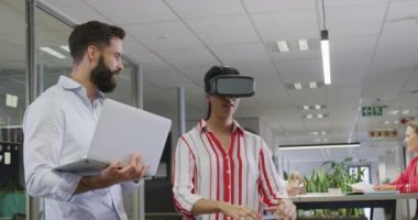 Ofiste VR kulaklığı kullanan mutlu erkek ve kadın iş arkadaşları. Modern bir ofiste çalışmak..